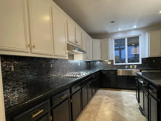 Kitchen after cabinet repaint with white uppers and black lowers