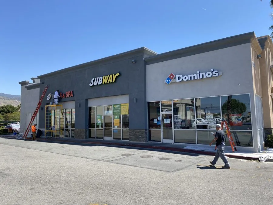 Multi-tenant retail center after exterior repaint in charcoal and gray