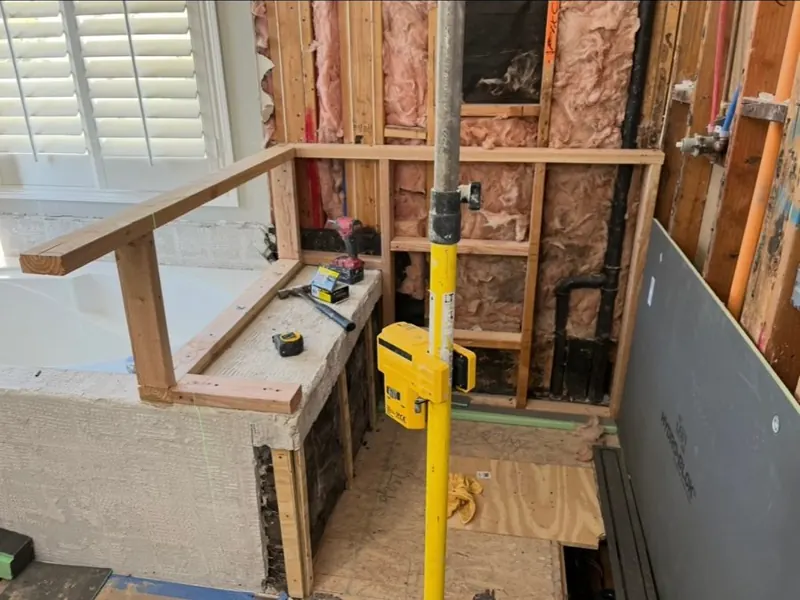 Framing & Rough-In — Shower bench and curb framed and plumbing roughed in after the old surround came out.