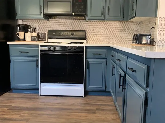 Cabinet Repaint — Cabinets refinished in a soft blue-green over a hand-sanded, primed surface.