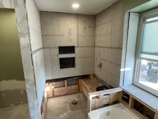 Backer Board & Niches — Cement backer board hung and the two stacked niches framed in, before waterproofing and tile.